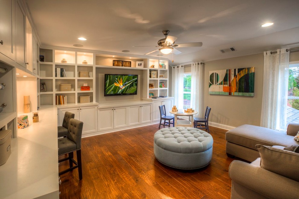 Imagen de sala de estar clásica con paredes beige, suelo de madera en tonos medios y televisor colgado en la pared