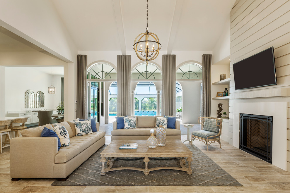 Inspiration for a timeless open concept family room remodel in Miami with beige walls, a standard fireplace and a wall-mounted tv