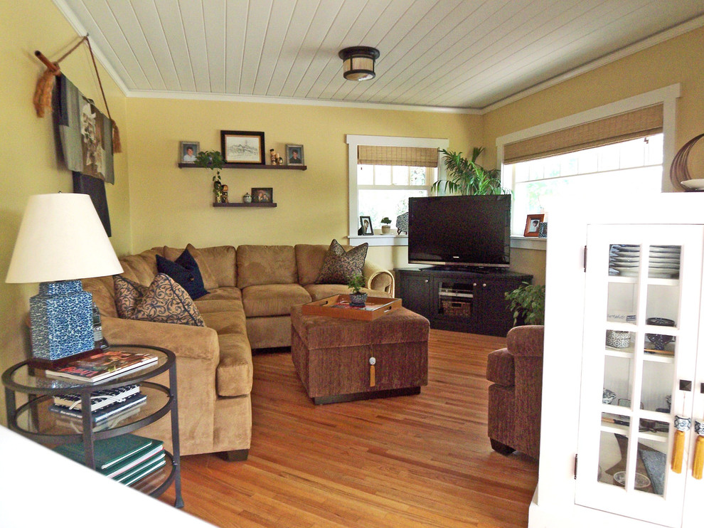 Klassisches Wohnzimmer mit beiger Wandfarbe, braunem Holzboden und freistehendem TV in Los Angeles