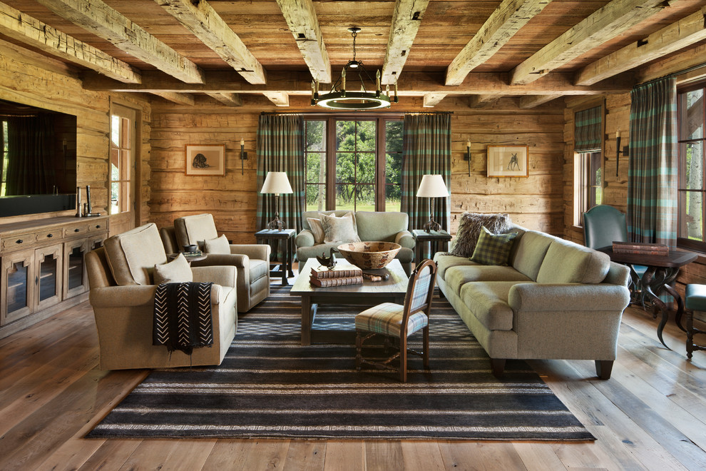 Inspiration for a large rustic enclosed medium tone wood floor family room remodel in Denver with a wall-mounted tv and brown walls