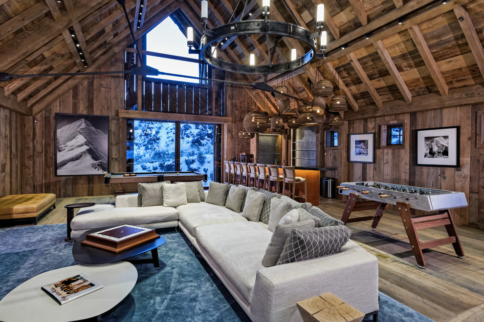 Example of a mountain style open concept medium tone wood floor and brown floor family room design in Denver with brown walls