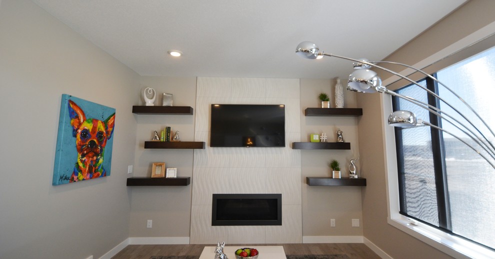 Minimalist laminate floor and multicolored floor family room photo in Calgary with white walls, a standard fireplace, a tile fireplace and a wall-mounted tv