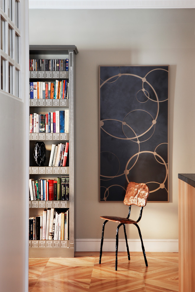 Ejemplo de sala de estar con biblioteca abierta escandinava pequeña sin chimenea y televisor con paredes beige y suelo de madera en tonos medios