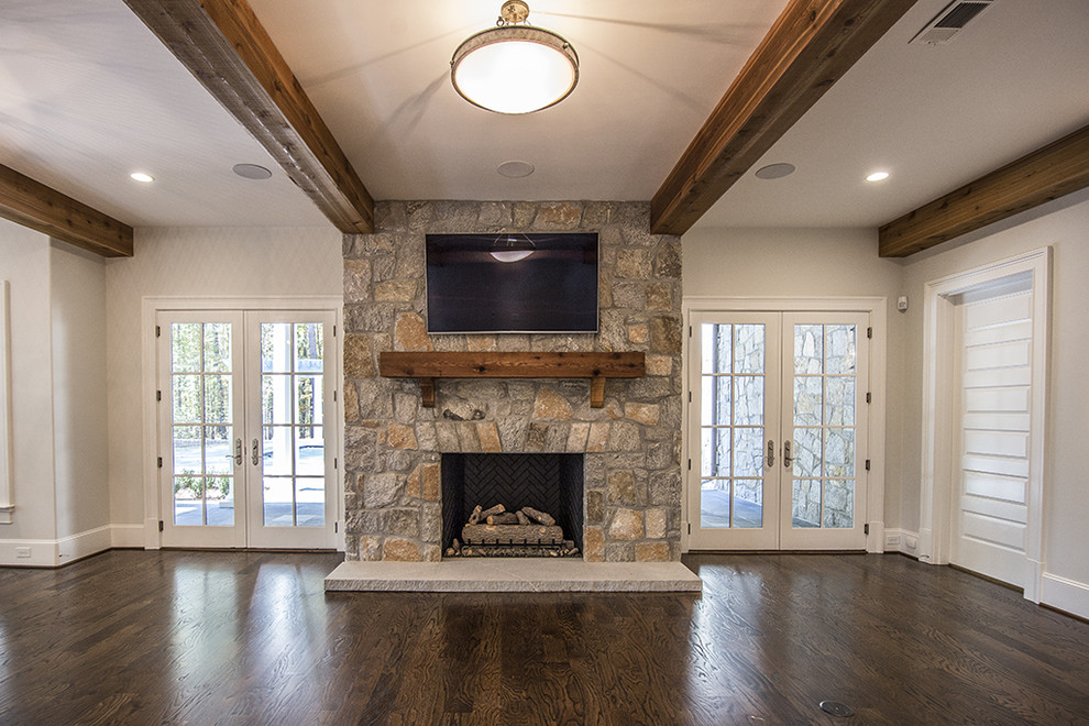 Family room - large craftsman open concept dark wood floor family room idea in Atlanta with gray walls, a standard fireplace, a stone fireplace and a wall-mounted tv