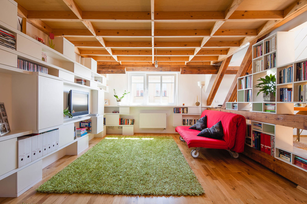 Diseño de sala de estar bohemia con paredes blancas, suelo de madera en tonos medios y televisor colgado en la pared
