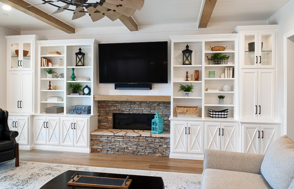 Свежая идея для дизайна: гостиная комната среднего размера в стиле кантри с фасадом камина из дерева и телевизором на стене - отличное фото интерьера