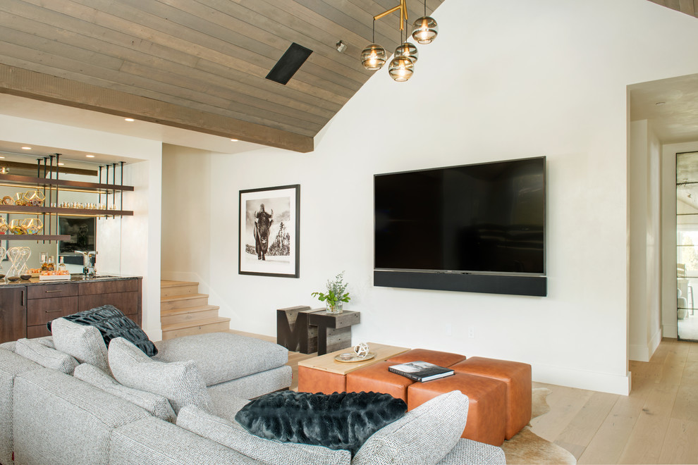 Ispirazione per un soggiorno minimalista di medie dimensioni e aperto con pareti beige, pavimento in legno massello medio, TV a parete, pavimento marrone e nessun camino