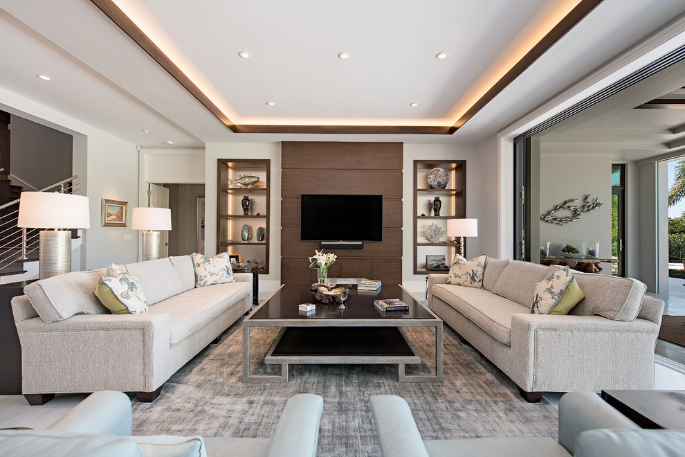 Modelo de sala de estar clásica renovada con paredes blancas, televisor colgado en la pared, suelo blanco y alfombra