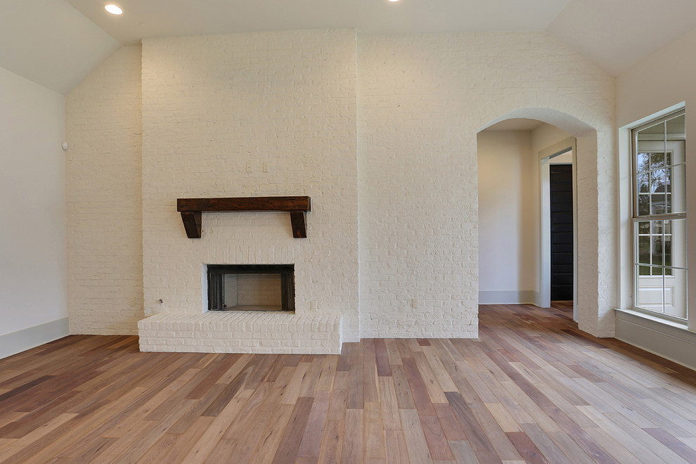 Inspiration for a medium sized classic enclosed games room in New Orleans with white walls, light hardwood flooring, a standard fireplace, a brick fireplace surround, a wall mounted tv and a reading nook.