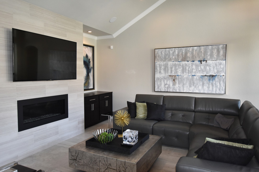 Exempel på ett mellanstort modernt allrum med öppen planlösning, med grå väggar, klinkergolv i porslin, en bred öppen spis, en spiselkrans i sten och en väggmonterad TV