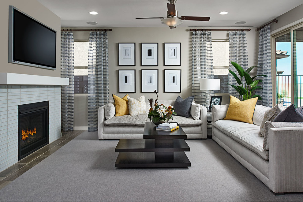 Immagine di un soggiorno design aperto con pareti grigie, camino classico e cornice del camino piastrellata