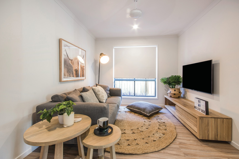 Diseño de sala de estar abierta contemporánea con paredes blancas, suelo laminado y televisor colgado en la pared