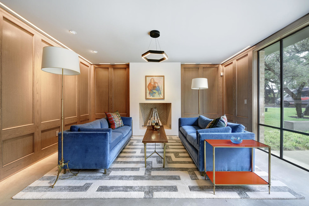 На фото: большая изолированная гостиная комната в стиле неоклассика (современная классика) с коричневыми стенами, бетонным полом, стандартным камином, серым полом и фасадом камина из штукатурки без телевизора с