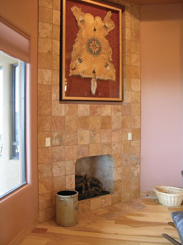 Foto di un soggiorno chic di medie dimensioni e aperto con pareti arancioni, parquet chiaro, camino classico e cornice del camino piastrellata