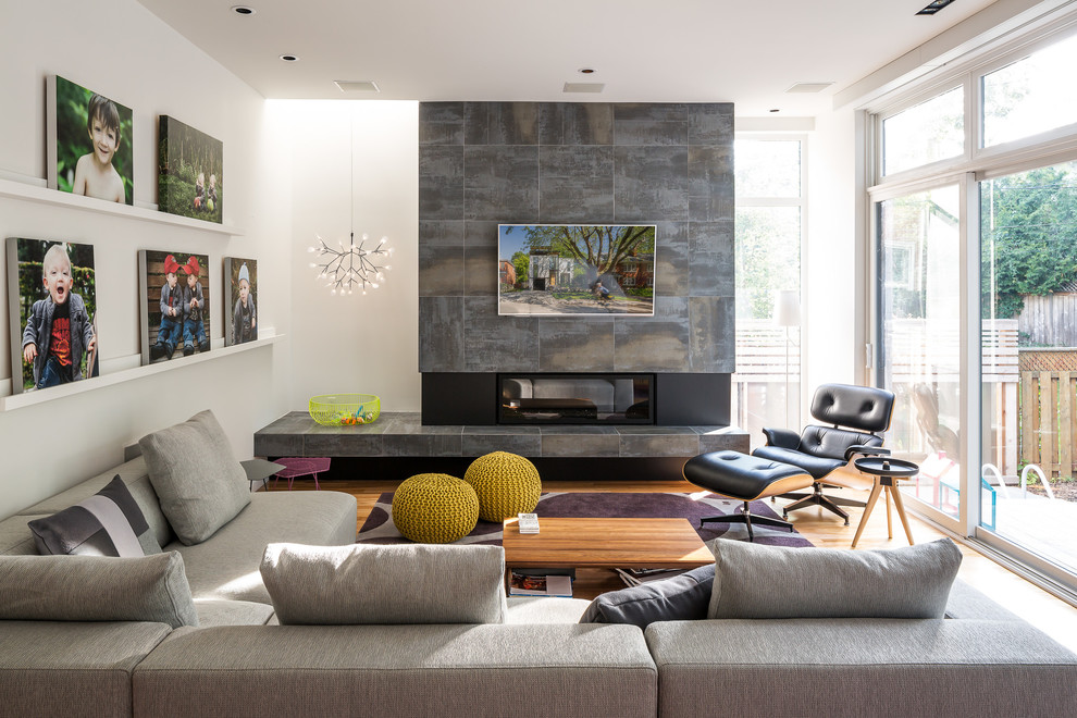 Modernes Wohnzimmer mit weißer Wandfarbe, hellem Holzboden, Gaskamin und TV-Wand in Ottawa
