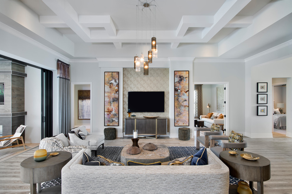 На фото: открытая гостиная комната в стиле неоклассика (современная классика) с серыми стенами, телевизором на стене и бежевым полом