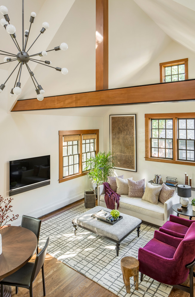 Imagen de sala de estar tipo loft tradicional renovada de tamaño medio sin chimenea con paredes blancas, suelo de madera en tonos medios, televisor colgado en la pared y suelo marrón