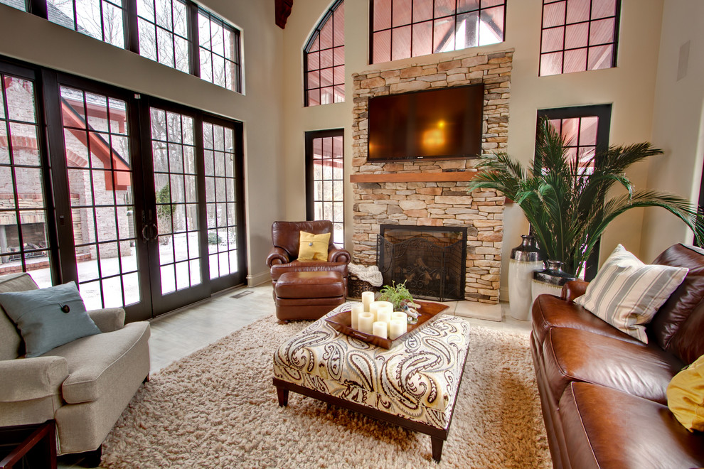 Ejemplo de sala de estar clásica con paredes beige, todas las chimeneas, marco de chimenea de piedra, televisor colgado en la pared y alfombra