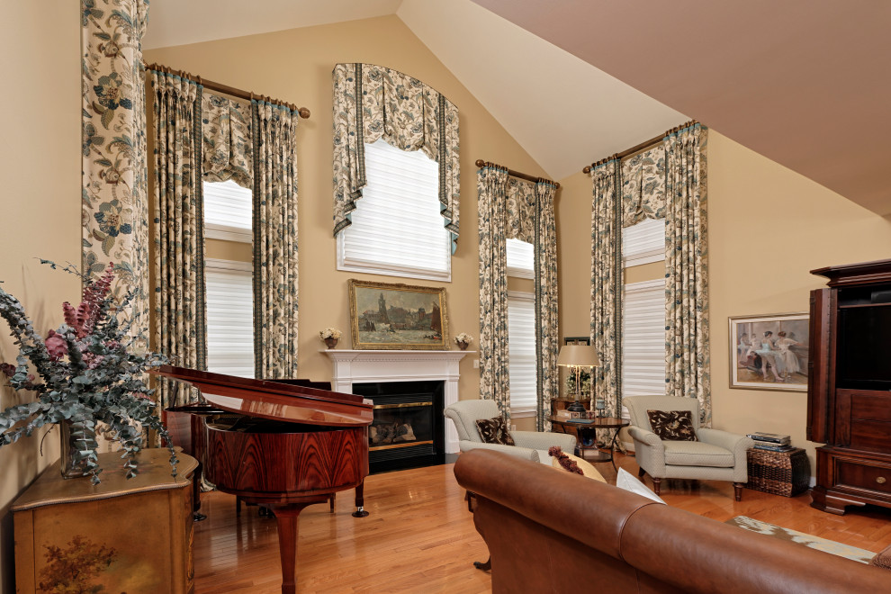Aménagement d'une grande salle de séjour classique ouverte avec un mur beige, un sol en bois brun et une cheminée standard.