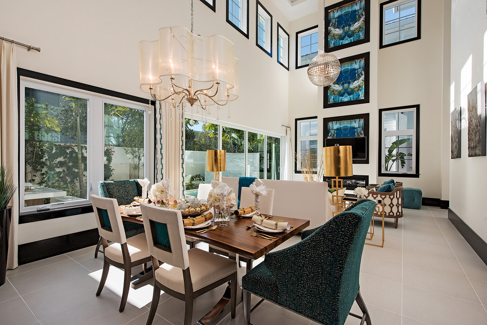 Geräumiges Modernes Esszimmer mit beiger Wandfarbe, Porzellan-Bodenfliesen, Kamin, Kaminumrandung aus Holz und grauem Boden in Miami