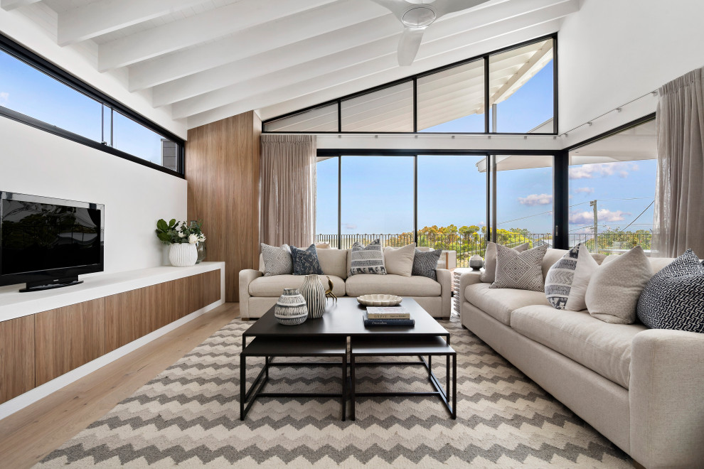Ispirazione per un grande soggiorno stile marino con pareti bianche, parquet chiaro, TV autoportante, pavimento beige e soffitto a volta