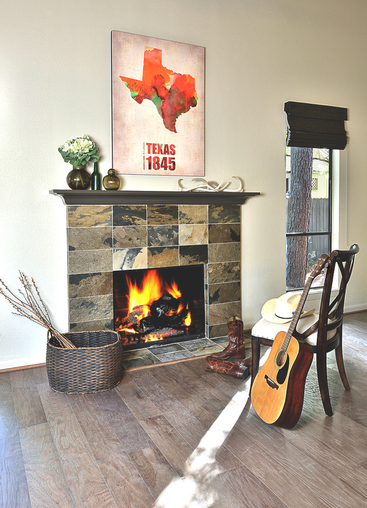 ヒューストンにあるお手頃価格の中くらいなトランジショナルスタイルのおしゃれなオープンリビング (グレーの壁、無垢フローリング、標準型暖炉、石材の暖炉まわり) の写真