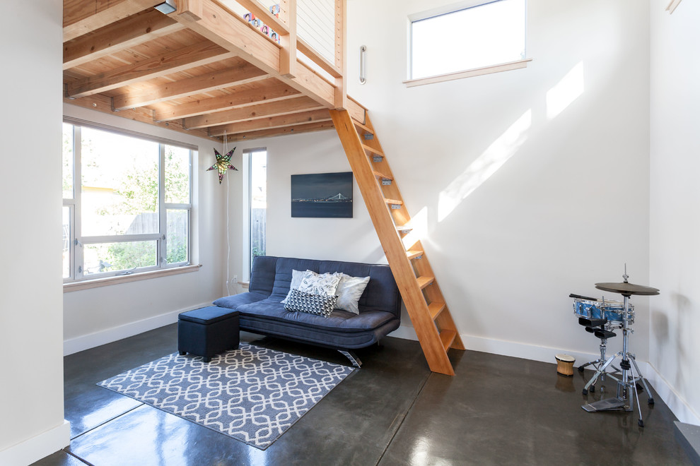 Imagen de sala de estar con rincón musical tipo loft contemporánea pequeña sin chimenea y televisor con paredes blancas y suelo de cemento