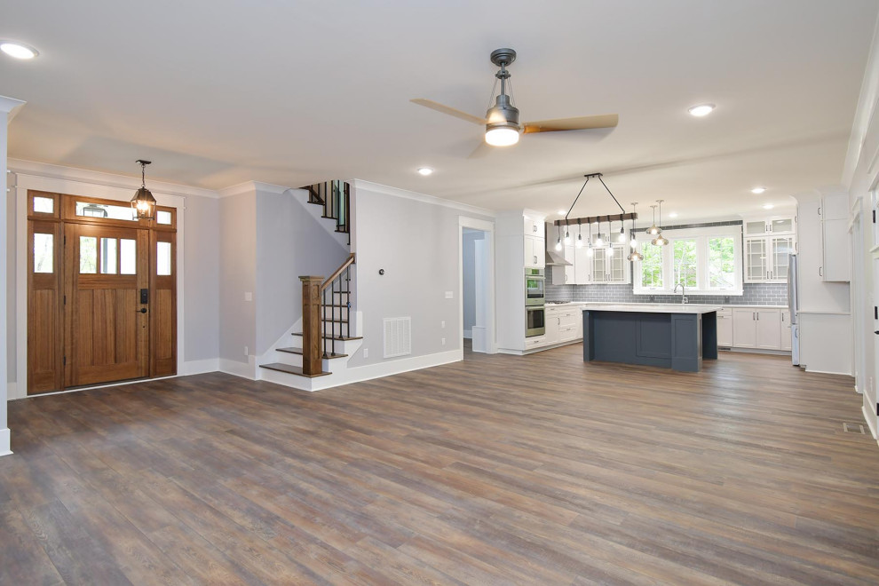 Mittelgroßes, Offenes Klassisches Wohnzimmer mit grauer Wandfarbe, Vinylboden, Kamin, gefliester Kaminumrandung und braunem Boden in Raleigh