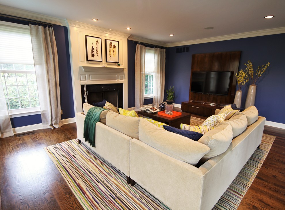 Источник вдохновения для домашнего уюта: большая открытая гостиная комната в современном стиле с синими стенами, темным паркетным полом, стандартным камином, фасадом камина из плитки и телевизором на стене