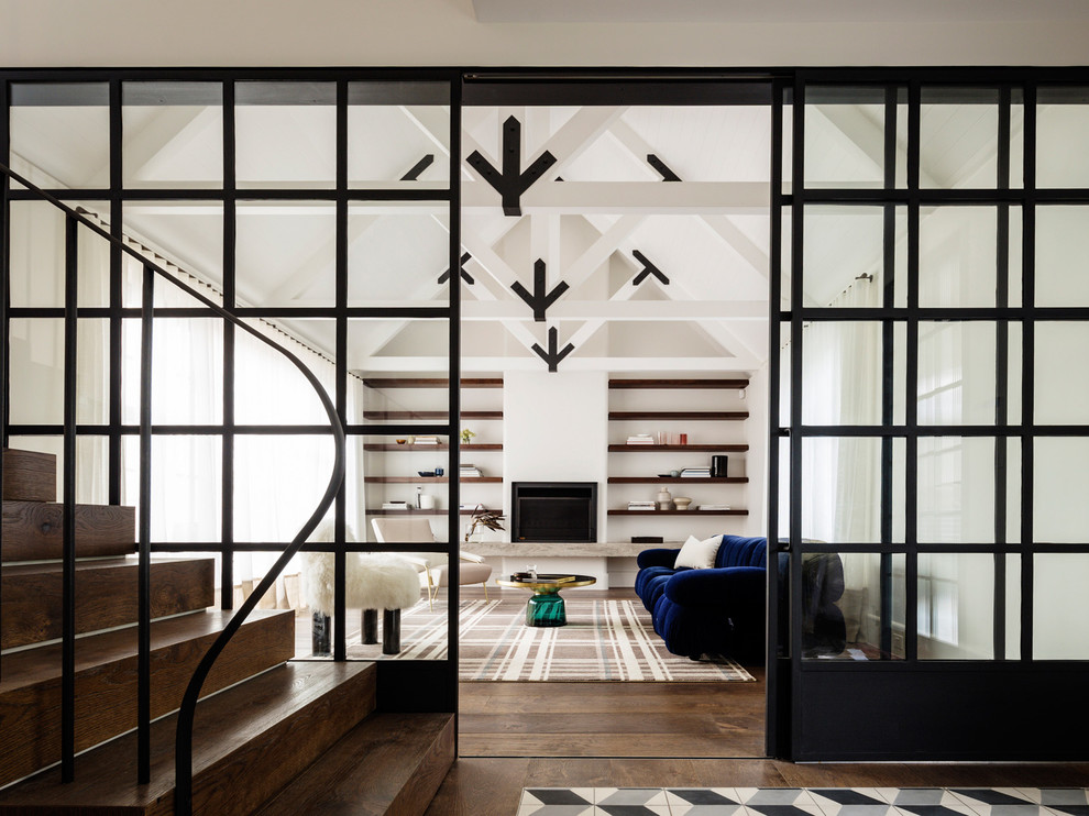 Источник вдохновения для домашнего уюта: гостиная комната в современном стиле с белыми стенами, темным паркетным полом, стандартным камином, синим диваном и ковром на полу