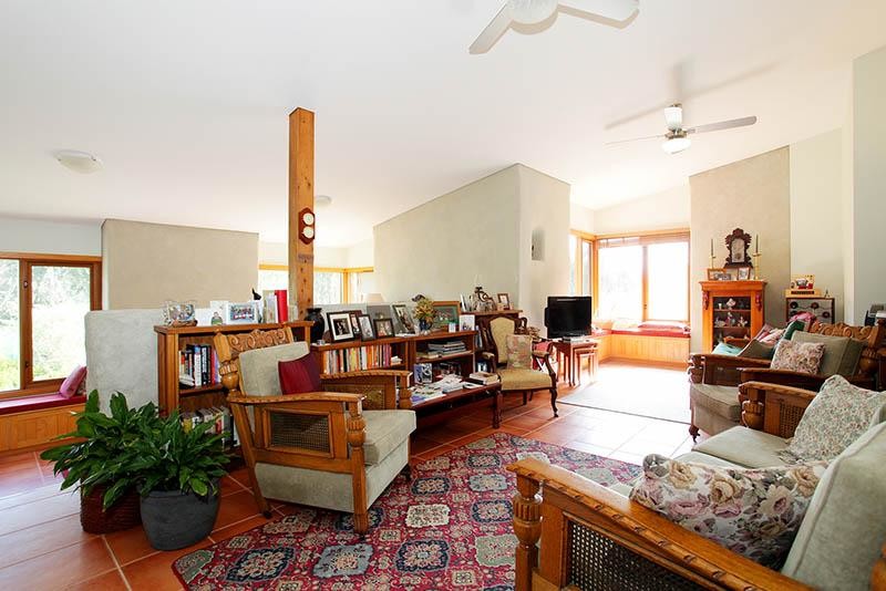 Imagen de sala de estar abierta tradicional de tamaño medio con paredes blancas, suelo de baldosas de terracota y televisor independiente