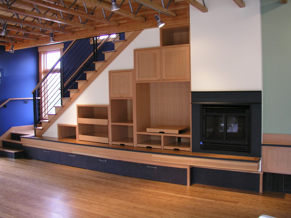 Cette photo montre une grande salle de séjour tendance ouverte avec un mur bleu, un sol en bois brun et une cheminée standard.