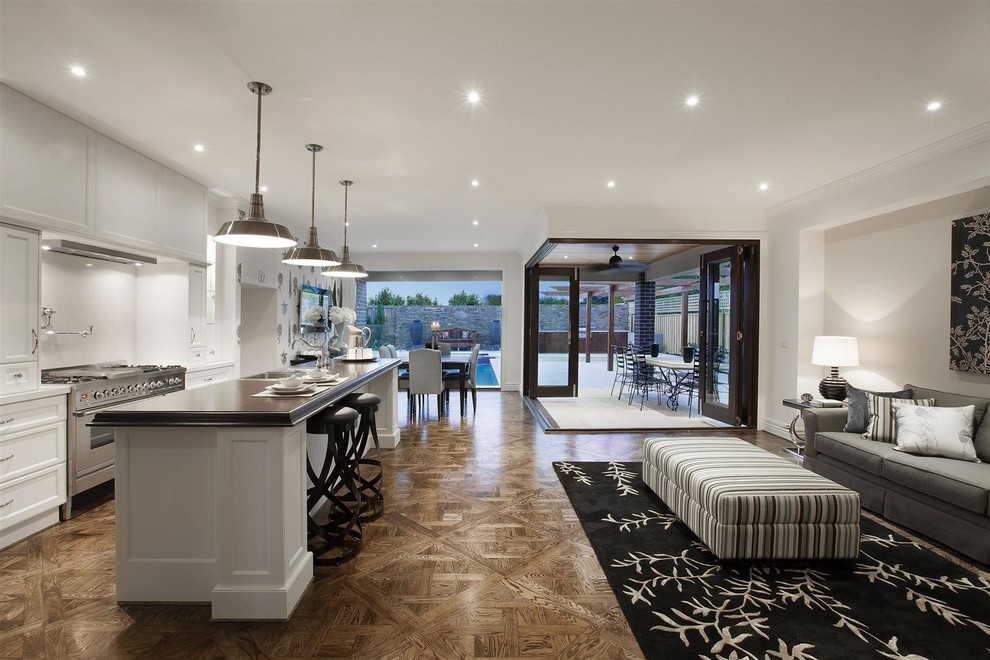 Large elegant open concept medium tone wood floor family room photo in Melbourne with white walls, no fireplace and no tv