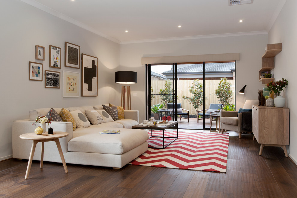 Mittelgroßes, Fernseherloses, Offenes Modernes Wohnzimmer ohne Kamin mit beiger Wandfarbe, dunklem Holzboden und braunem Boden in Melbourne