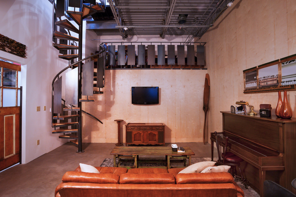 Foto de sala de estar con rincón musical industrial de tamaño medio con paredes beige, suelo de cemento y televisor colgado en la pared