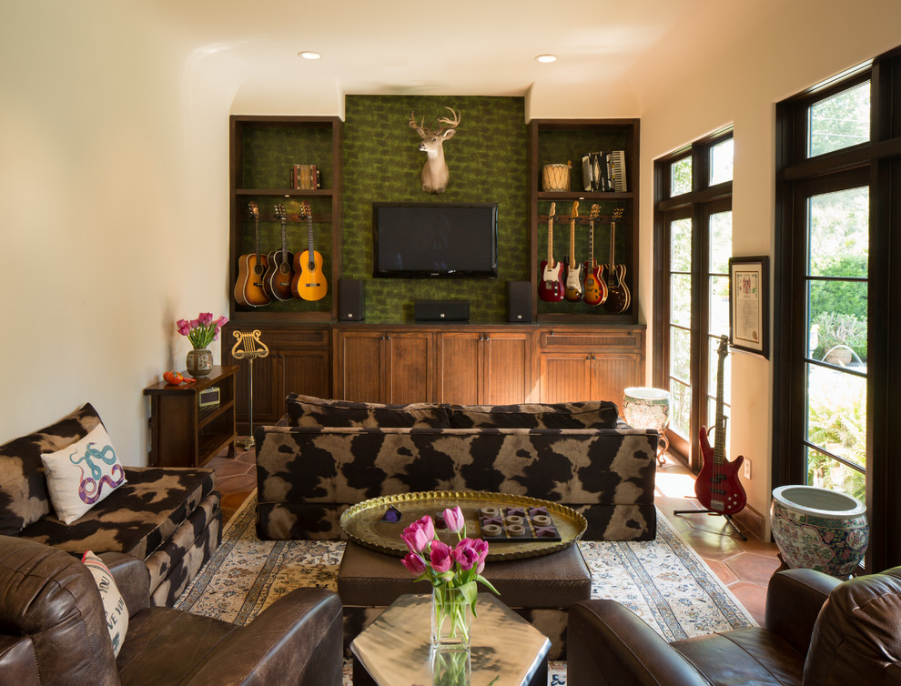 Mittelgroßes Mediterranes Musikzimmer ohne Kamin mit grüner Wandfarbe, Terrakottaboden und TV-Wand in Houston