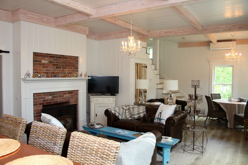 Exemple d'une salle de séjour éclectique de taille moyenne et ouverte avec un mur blanc, parquet clair, une cheminée standard, un manteau de cheminée en brique et un téléviseur d'angle.