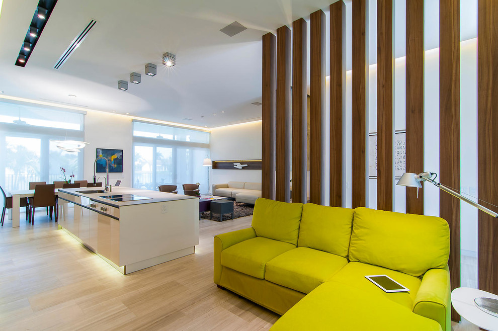 Imagen de sala de estar abierta actual pequeña con paredes blancas, pared multimedia y suelo de madera clara