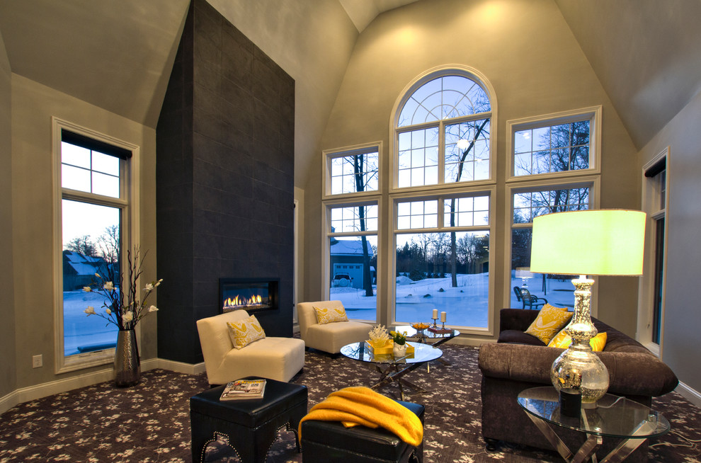 На фото: большая открытая гостиная комната в современном стиле с серыми стенами, ковровым покрытием, стандартным камином и фасадом камина из плитки