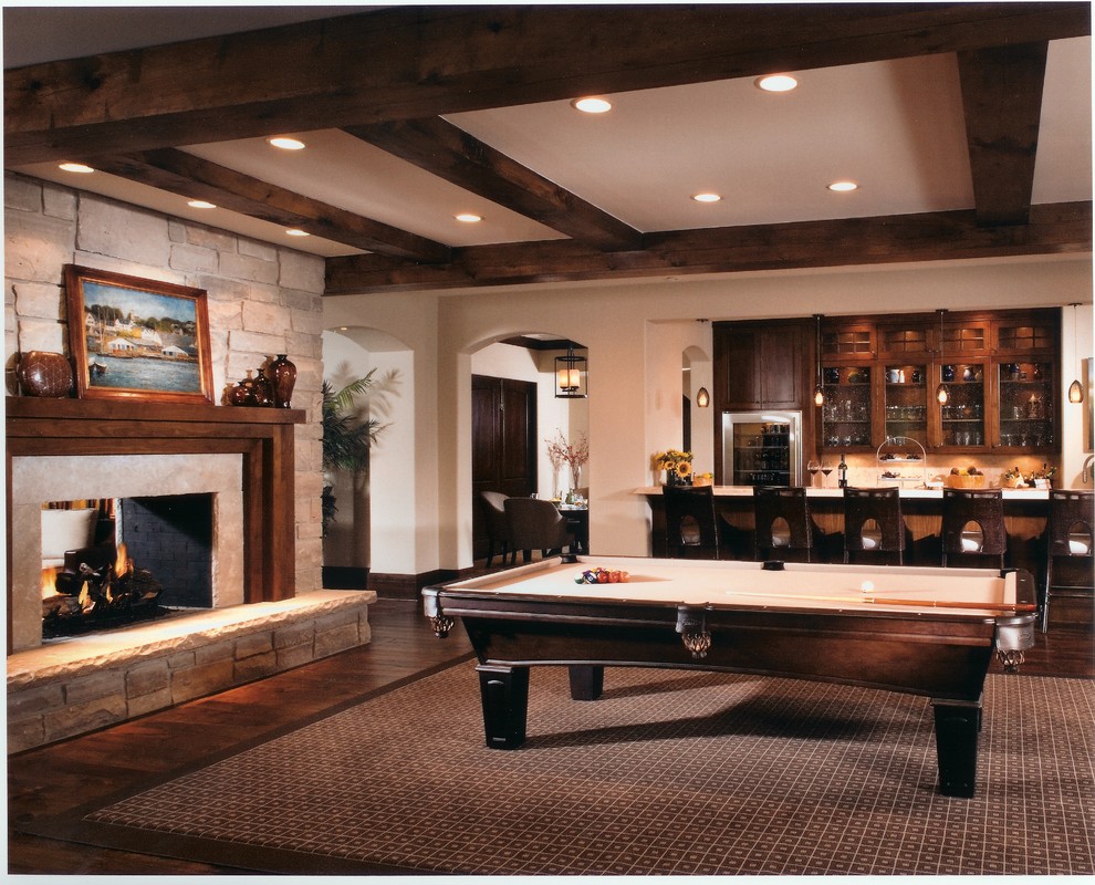 シカゴにある広いトラディショナルスタイルのおしゃれな独立型ファミリールーム (ホームバー、濃色無垢フローリング、両方向型暖炉、石材の暖炉まわり、茶色い床) の写真