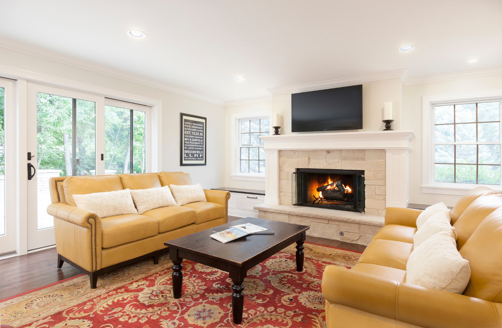 Large traditional open plan games room in Milwaukee with beige walls, medium hardwood flooring, a standard fireplace, a stone fireplace surround and a wall mounted tv.