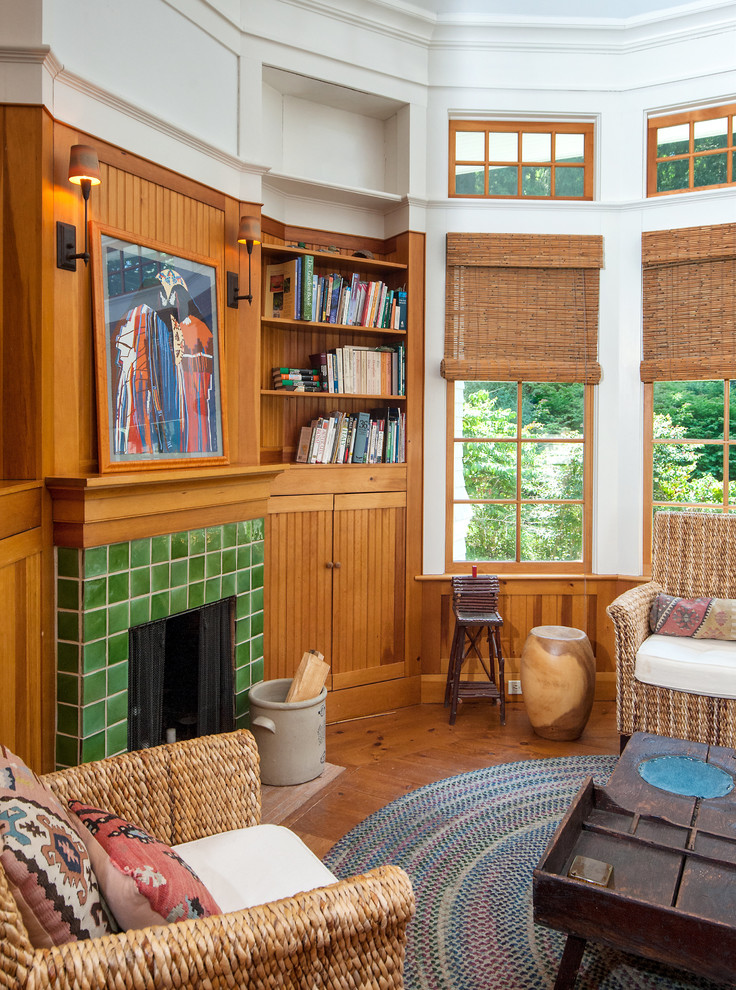 Exemple d'une salle de séjour nature de taille moyenne et fermée avec un mur blanc, un sol en bois brun, une cheminée standard, un manteau de cheminée en carrelage et un sol marron.