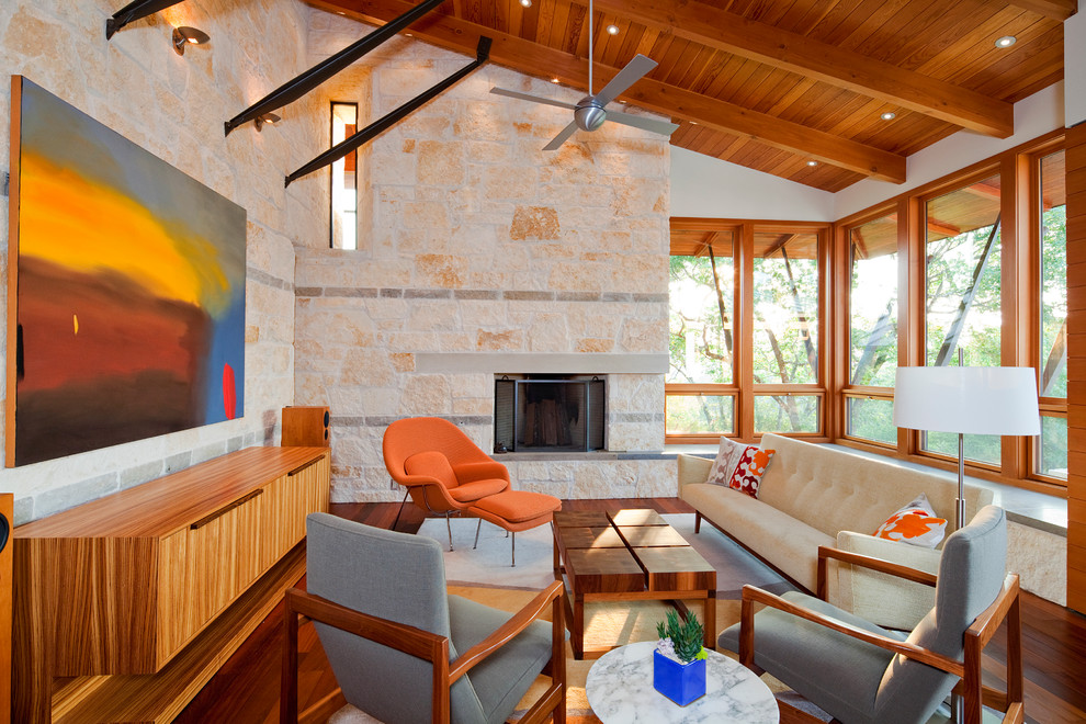 На фото: гостиная комната в современном стиле с бежевыми стенами, стандартным камином и фасадом камина из камня с
