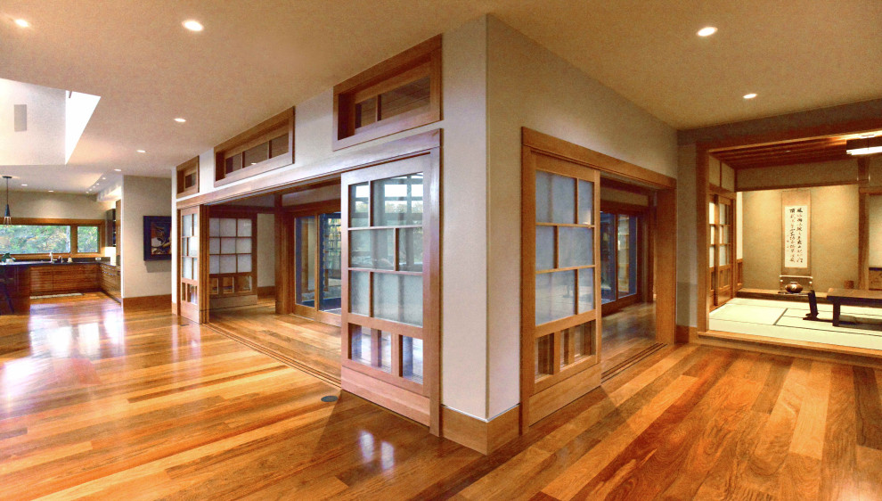 Großes, Offenes, Fernseherloses Asiatisches Wohnzimmer ohne Kamin mit braunem Holzboden, grauer Wandfarbe, braunem Boden, gewölbter Decke und Holzwänden in Austin