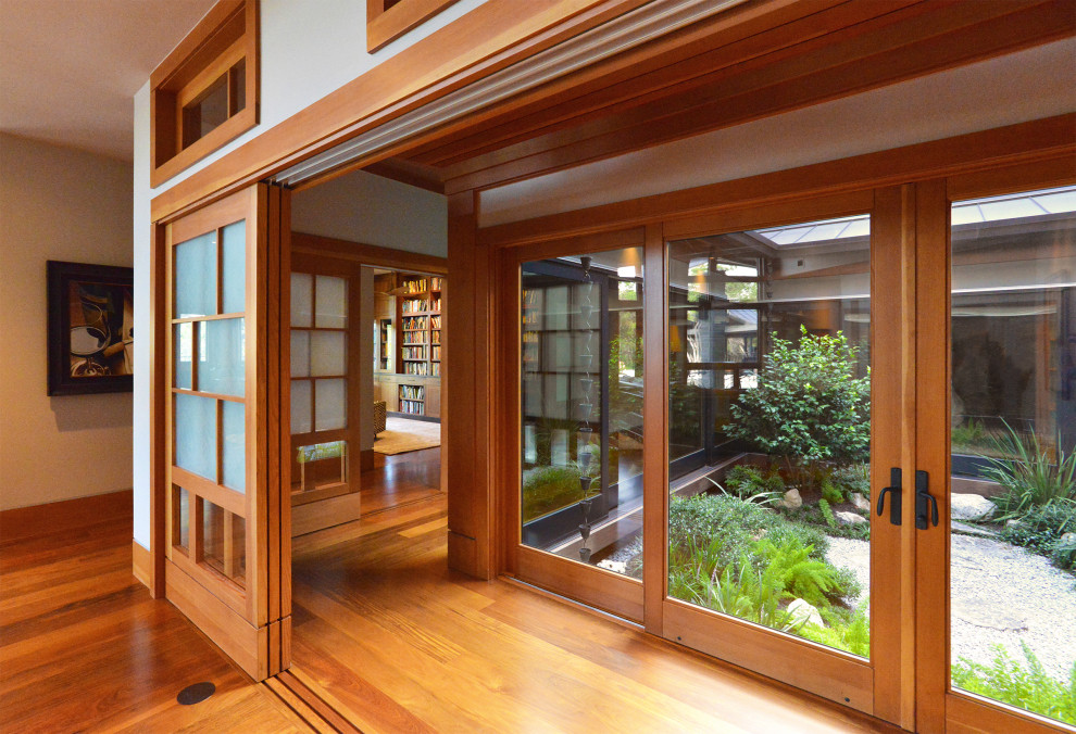 Diseño de sala de estar abierta de estilo zen grande con suelo de madera en tonos medios, paredes grises y suelo marrón