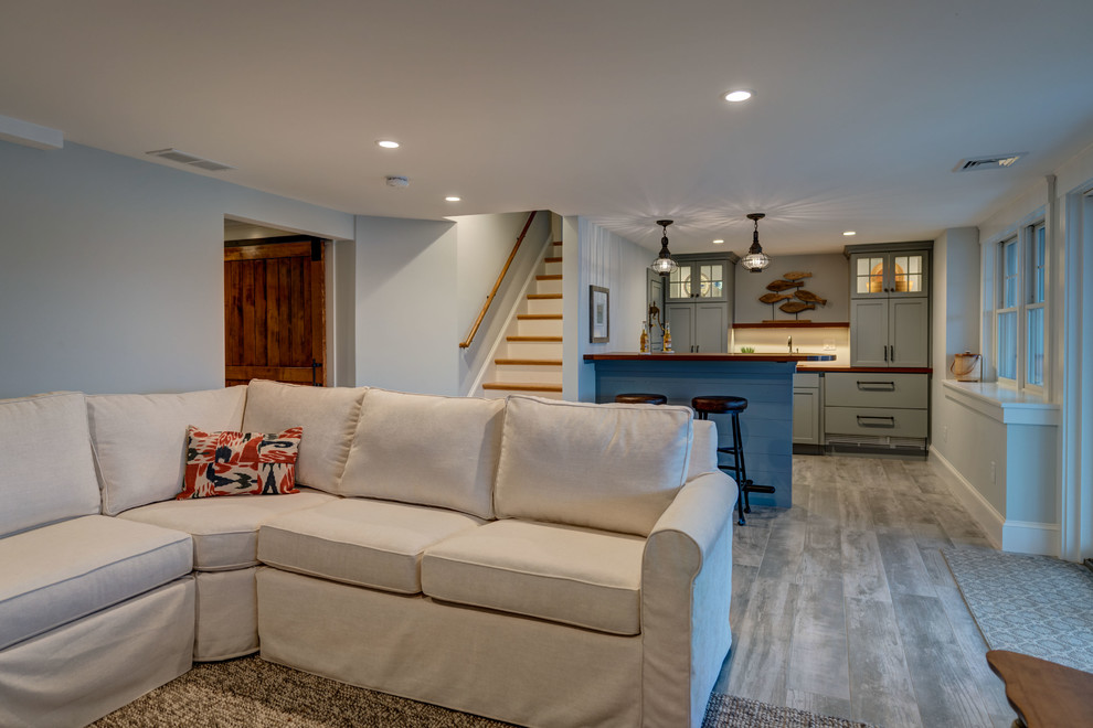 Example of a mid-sized beach style open concept porcelain tile and gray floor family room design in Boston with a bar and blue walls