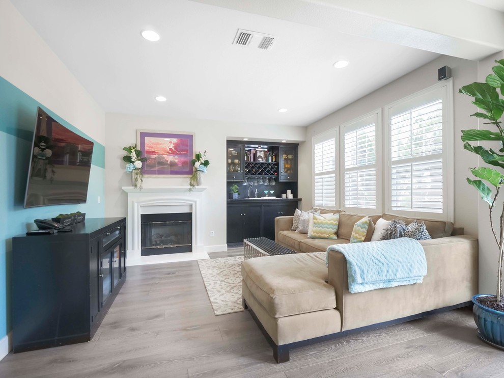 Offenes Modernes Wohnzimmer mit Hausbar, bunten Wänden, braunem Holzboden, Kamin, TV-Wand und grauem Boden in San Francisco