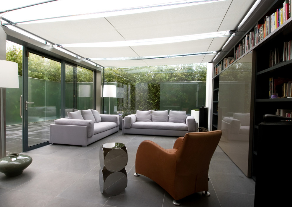Modelo de sala de estar con biblioteca abierta contemporánea de tamaño medio con paredes grises y pared multimedia
