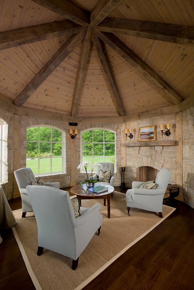 Inspiration pour une salle de séjour traditionnelle avec un mur beige, parquet foncé, une cheminée standard et un manteau de cheminée en pierre.