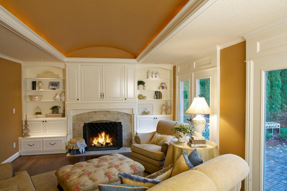 Diseño de sala de estar clásica con parades naranjas, suelo de madera oscura, todas las chimeneas y televisor retractable
